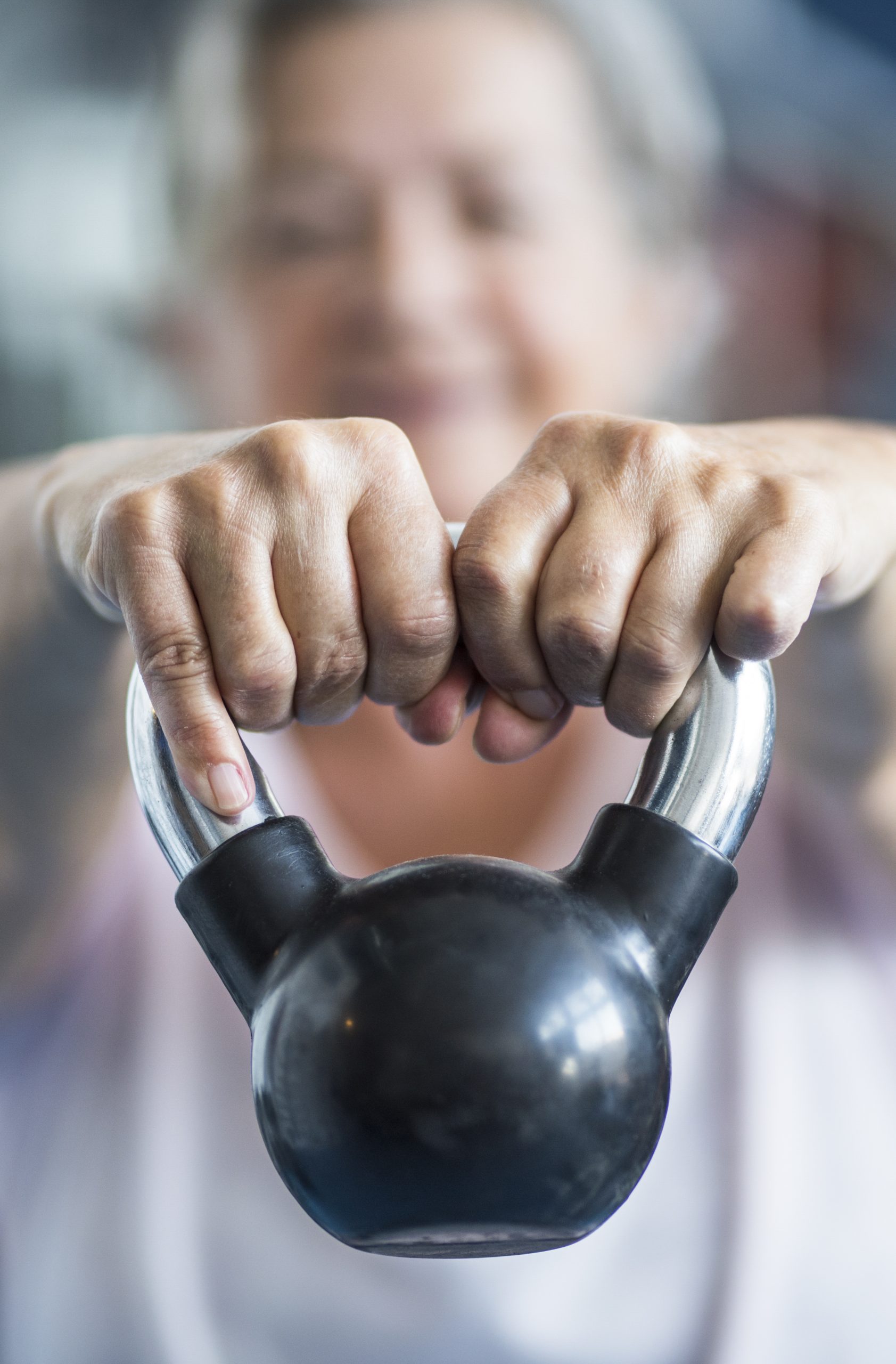 MUJER MAYOR HACIENDO EJERCICIO CON KETTLEBELL